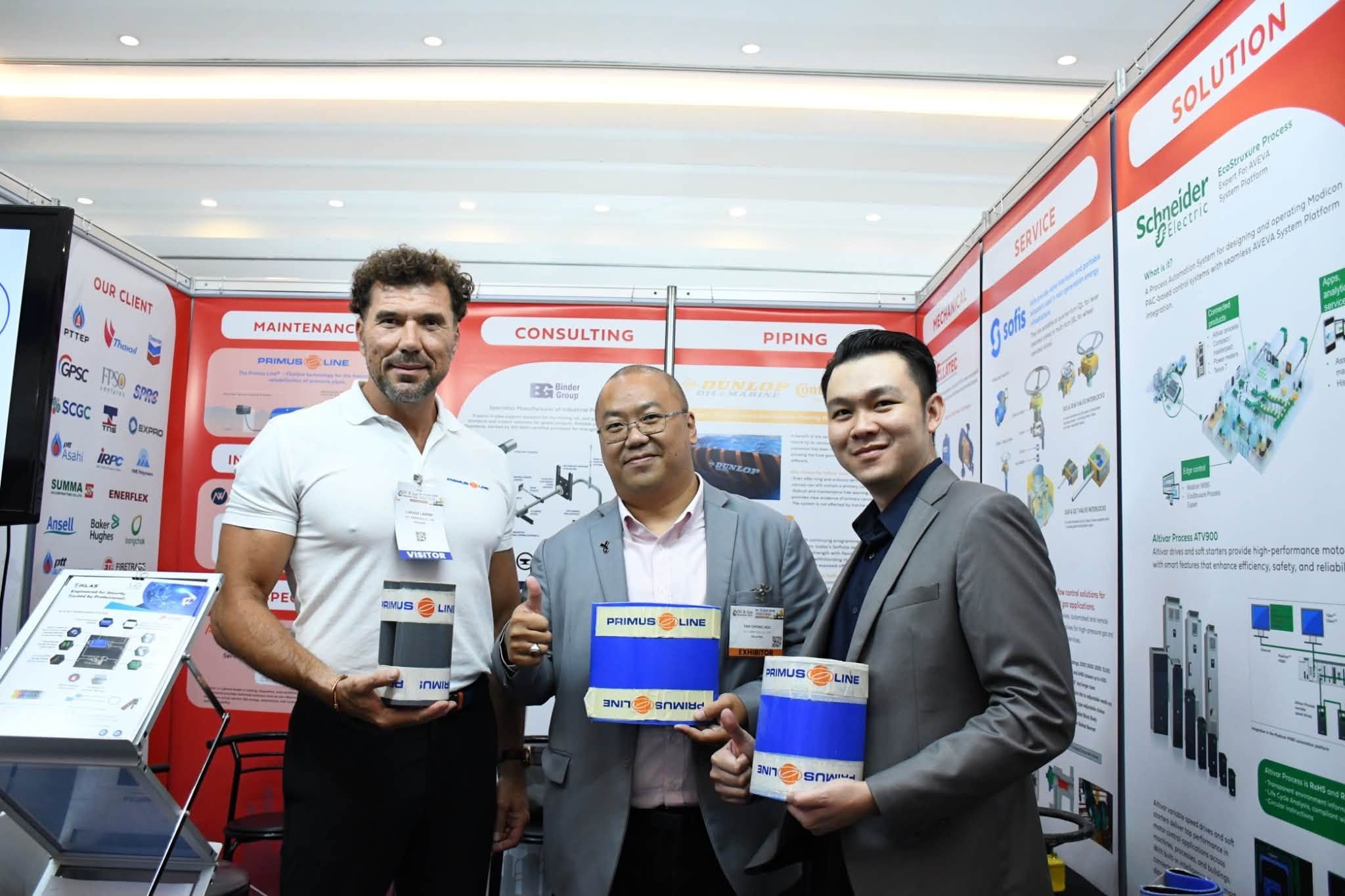 Partners holding Primus Line trenchless pipeline rehabilitation samples at the JST Group booth